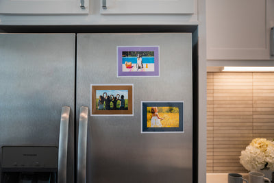 Magnetic photo pocket frames with included metallic colored frames in Amythest, Lapiz Lazuli and Gold; displayed on stainless steel fridge.  